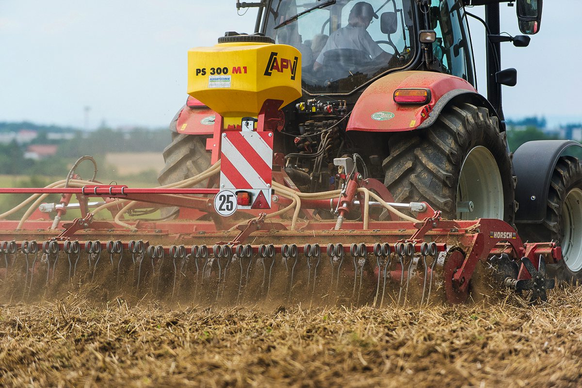 Traktor mit Sämaschine fährt über einen Acker