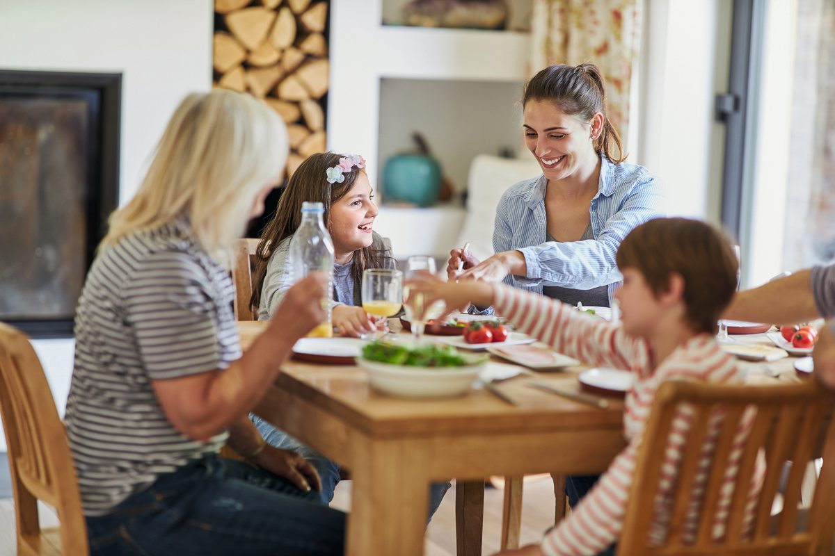 Vier Personen sitzen um einen Tisch und essen