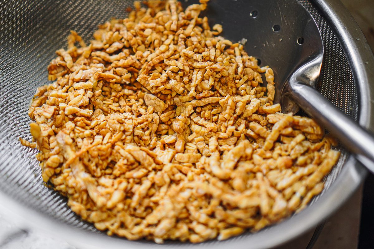 Tempeh-Flocken in einem Küchensieb