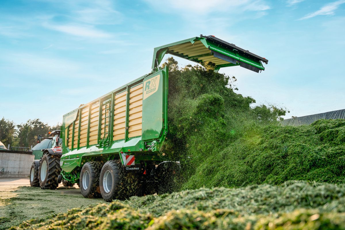 Ein Ladewagen lädt frischen Grünschnitt auf ein Silo ab