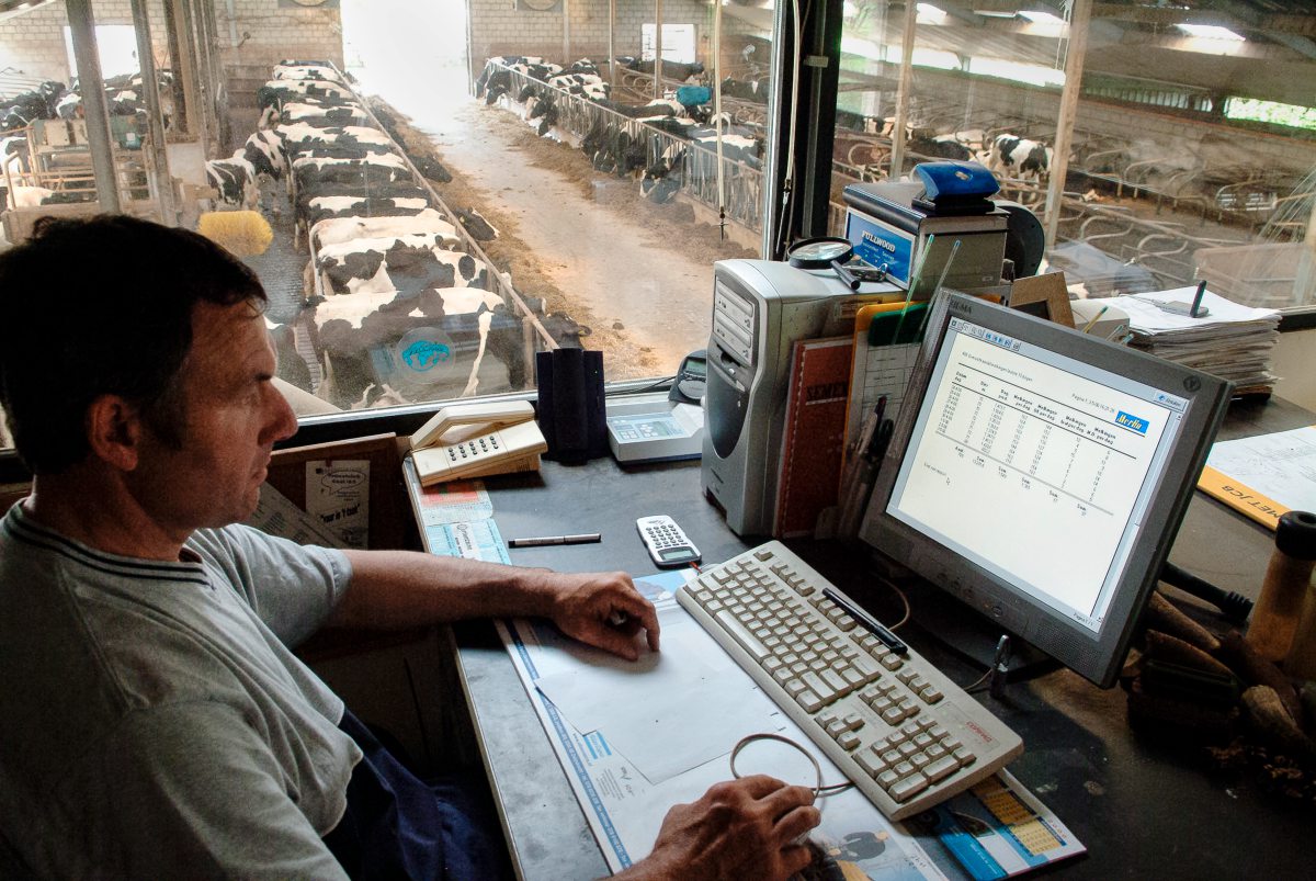 Landwirt sitzt im Stallbüro am Computer