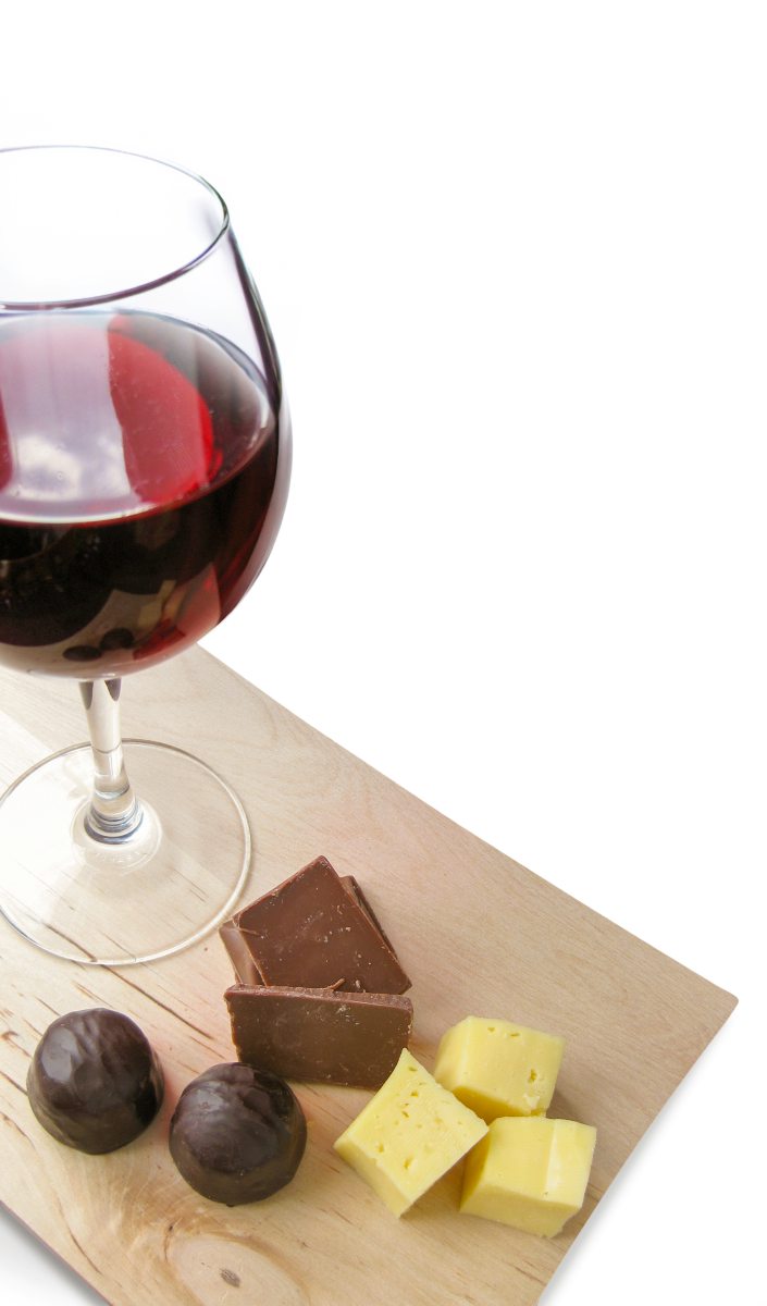 Wein, Trauben, Schokolade und Käse auf einem Holzbrett