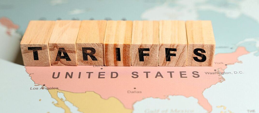USA Karte, auf der mit Würfeln der Schriftzug "Tariffs" steht