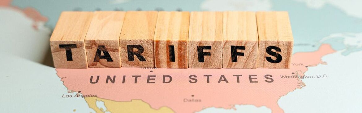 USA Karte, auf der mit Würfeln der Schriftzug "Tariffs" steht