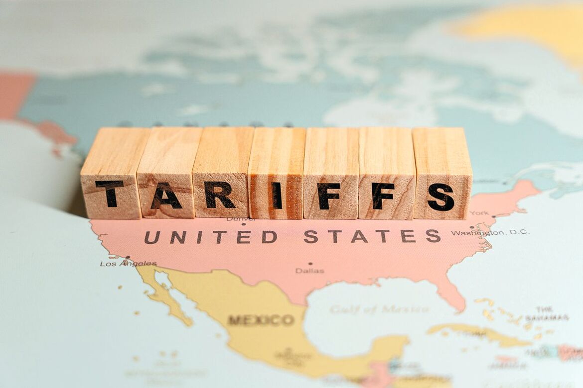 USA Karte, auf der mit Würfeln der Schriftzug "Tariffs" steht