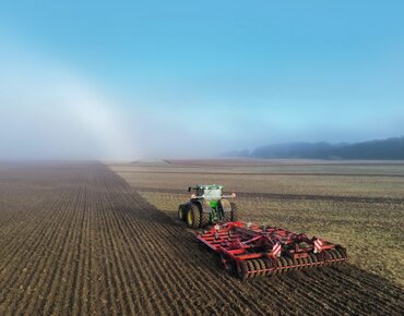 Ein Traktor bereitet einen Acker für die Aussaat vor