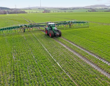 Traktor bringt flüssigen Wirtschaftsdünger auf Acker aus