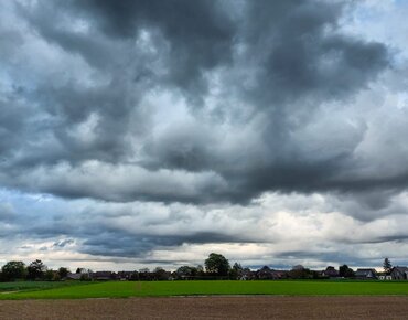 Dunkle Wolken über einer Agrarlandschaft