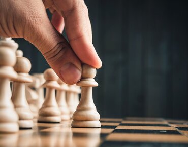 Finger bewegen eine Schachfigur