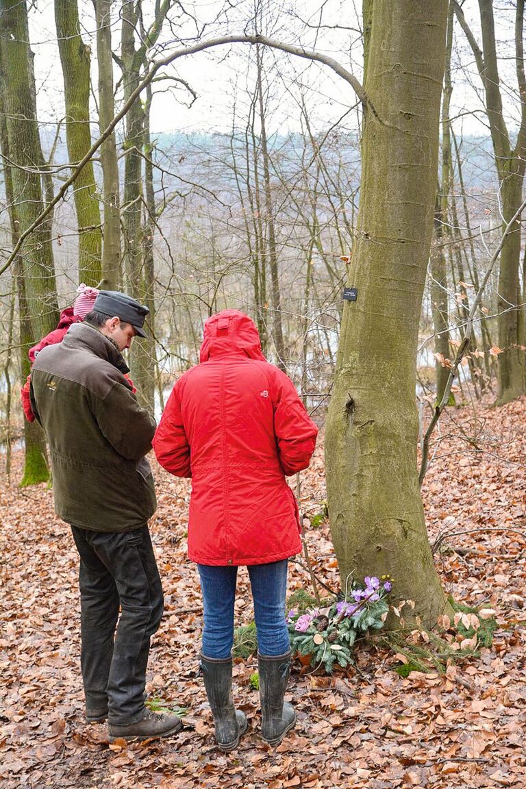 Menschen bei einem Waldbegräbnis