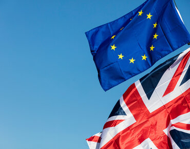 EU- und UK-Flagge vor blauem Himmel