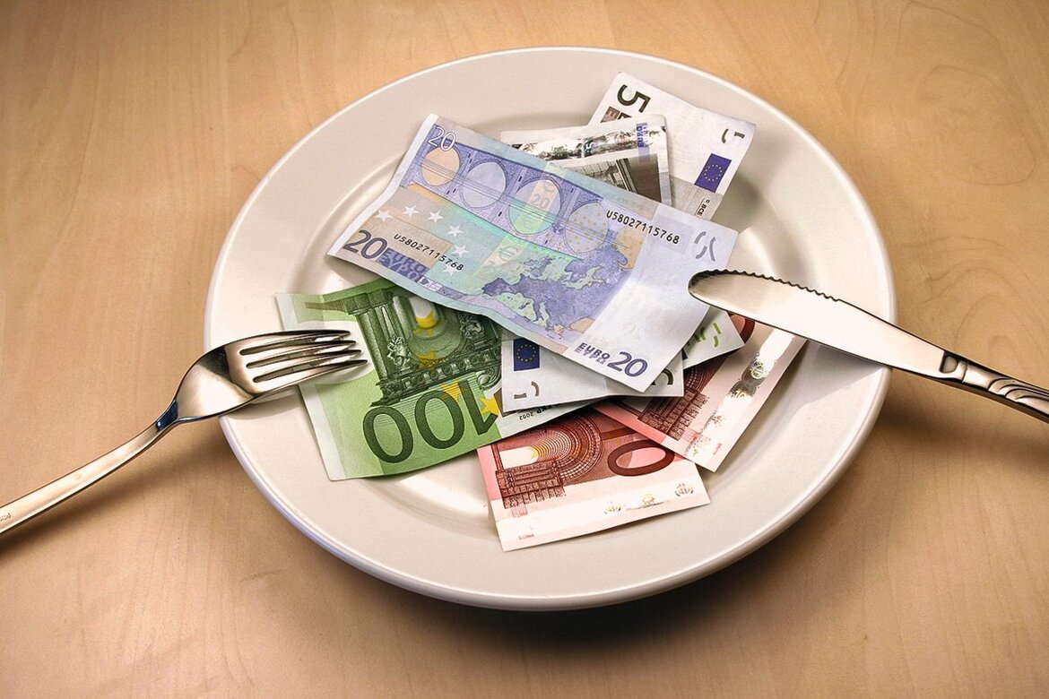 Geldscheine liegen auf einem Teller, daneben Besteck