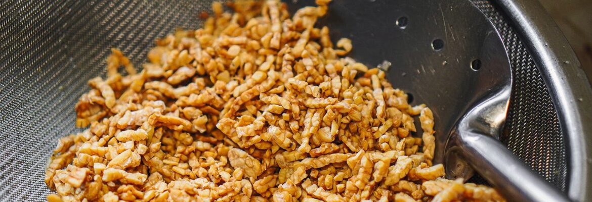 Tempeh-Flocken in einem Küchensieb