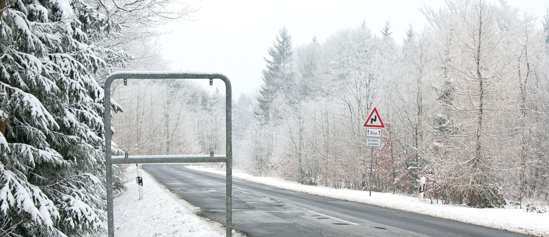 Eine verschneite Landstraße, ein Rahmen mit fehlendem Ortsschild