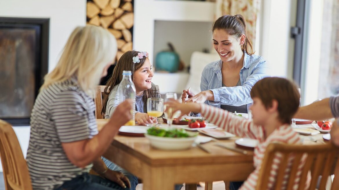 Vier Personen sitzen um einen Tisch und essen