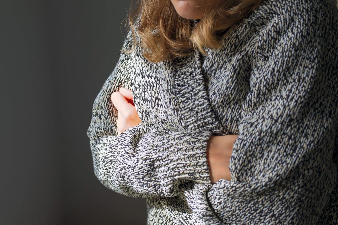 fröstelnde Frau in Strickpulli