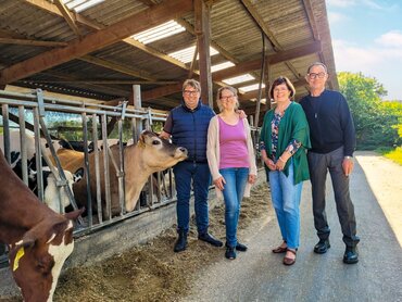 Eine Familie vor einem Kuh-Außenstall