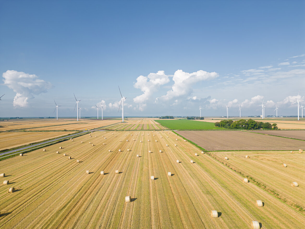Abgeerntetes Getreidefeld mit Windkraftanlagen in Nordfriesland, Deutschland 