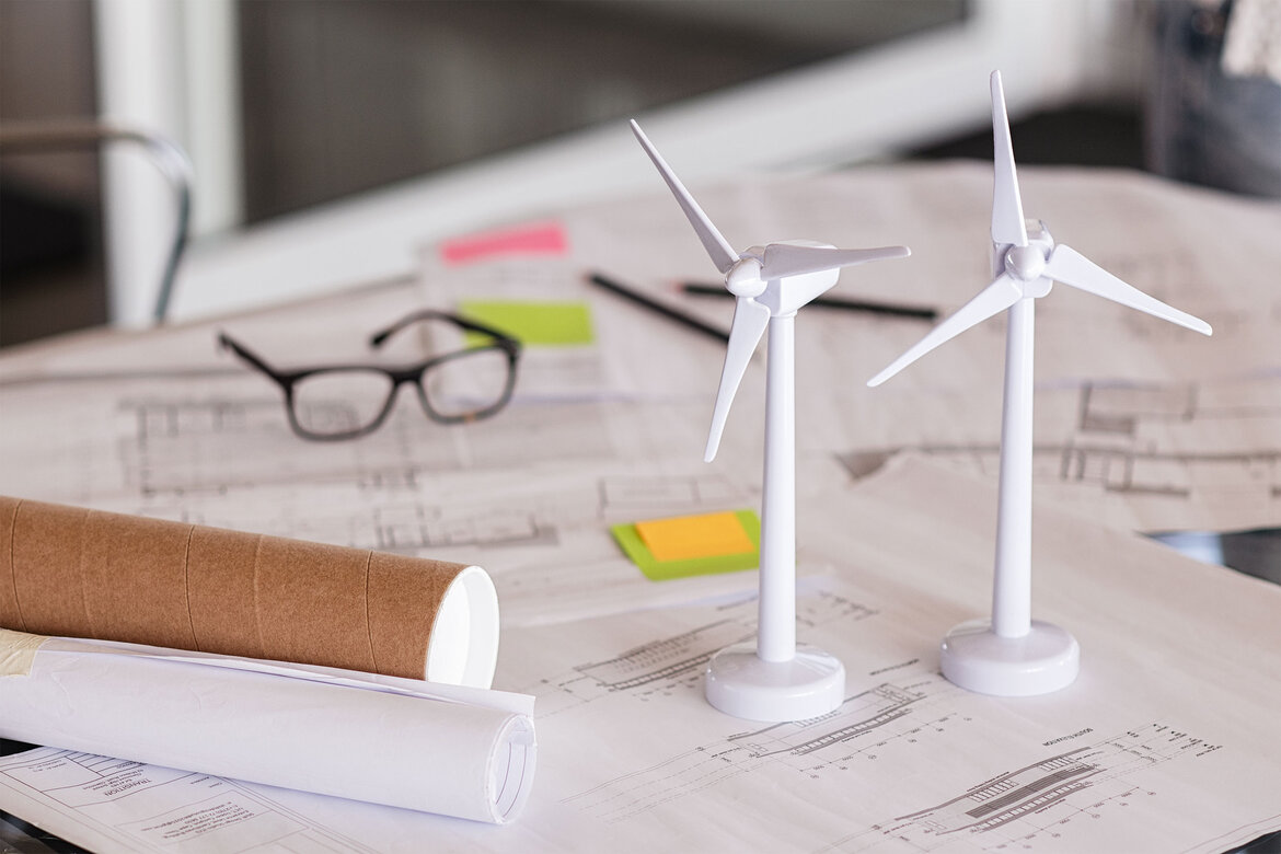 Modelle von Windrädern auf einem Planungsschreibtisch platziert