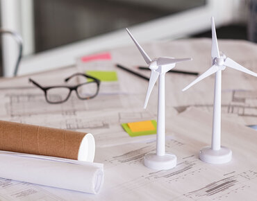Modelle von Windrädern auf einem Planungsschreibtisch platziert