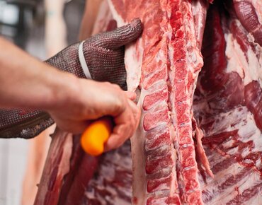 Schweinehälfte wird im Schlachthof zerlegt