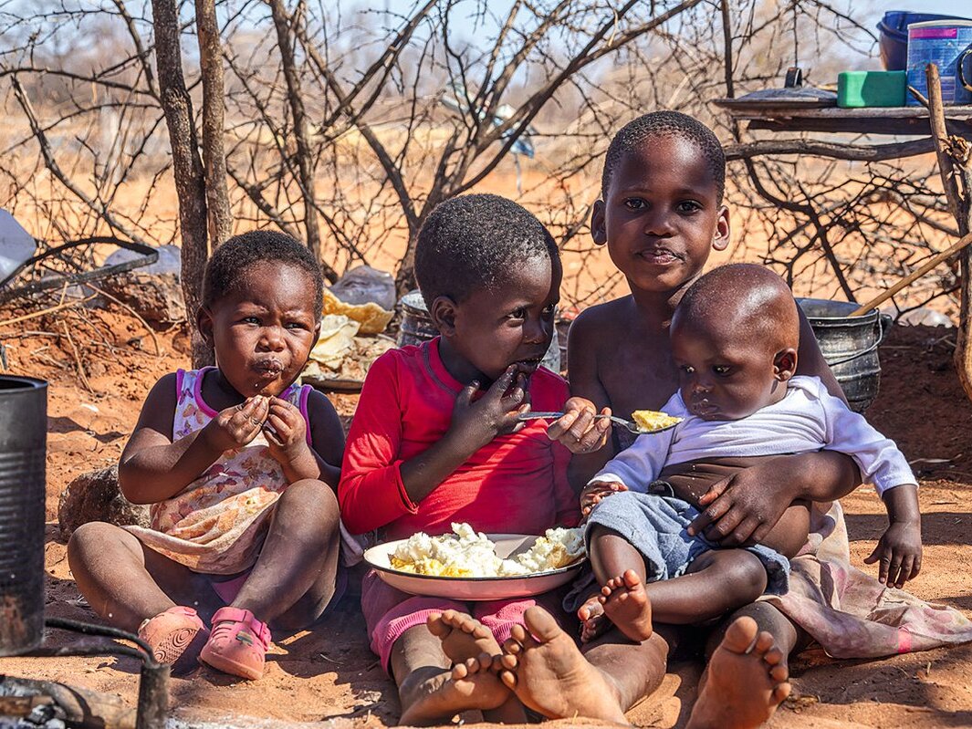 Vier Schwarze Kinder sitzen beim Essen